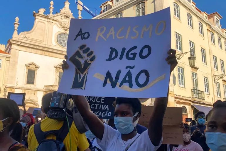 Say no to racism' during an anti-racism protest in Lisbon